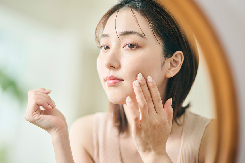 鏡で肌の状態を確認している女性